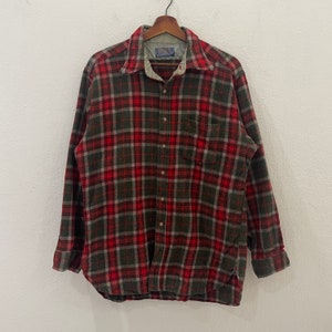 Puede incluir: Una camisa de franela a cuadros rojos, verdes y blancos con cierre de botones y mangas largas.