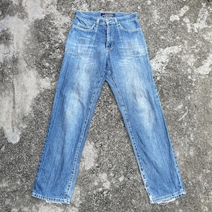 Könnte beinhalten: Eine blaue Jeanshose mit geradem Bein und mehreren Taschen. Die Jeans hat einen ausgewaschenen Look und ist aus einem weichen, bequemen Stoff gefertigt.