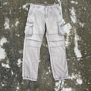 May include: A pair of gray cargo pants with multiple pockets and a drawstring at the waist.