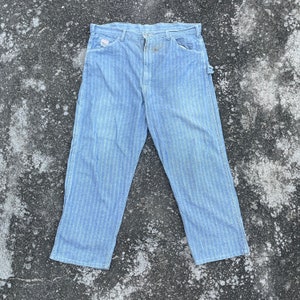 May include: A pair of blue striped work pants with a tool loop on the right side.