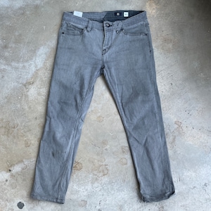 May include: Gray denim jeans with a slim fit. The jeans have a dark gray wash and a slightly distressed look.