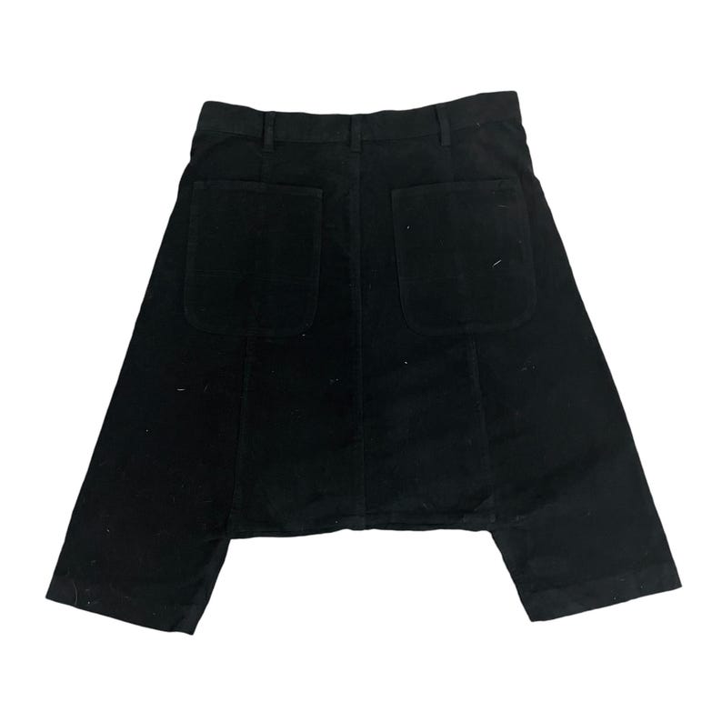 Puede incluir: Pantal&oacute;n de pana negro con un dise&ntilde;o &uacute;nico que presenta dos grandes bolsillos en la parte posterior. El pantal&oacute;n tiene una pierna ancha y una longitud recortada.