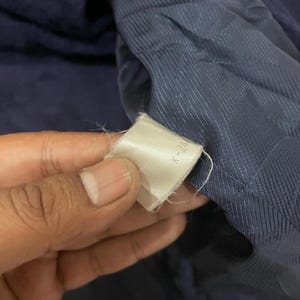 May include: Close-up of a navy blue fabric with a white tag that says "K-214".
