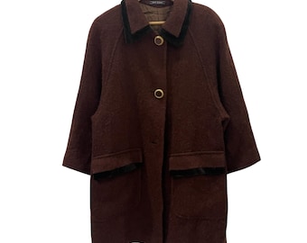 May include: A brown wool coat with a black velvet collar and pockets. The coat has a single button closure and gold-toned buttons.