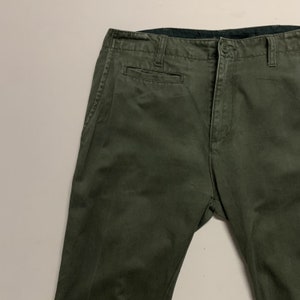 May include: A pair of dark green cargo pants with a front pocket and a button fly.