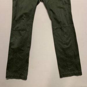 May include: A pair of dark green cargo pants with a straight leg fit. The pants have a subtle texture and are made of a durable fabric.