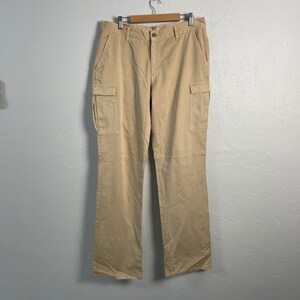 Könnte beinhalten: Eine beige Cargohose mit mehreren Taschen.