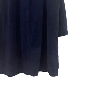 May include: A dark blue long-sleeved dress with a simple, classic design.