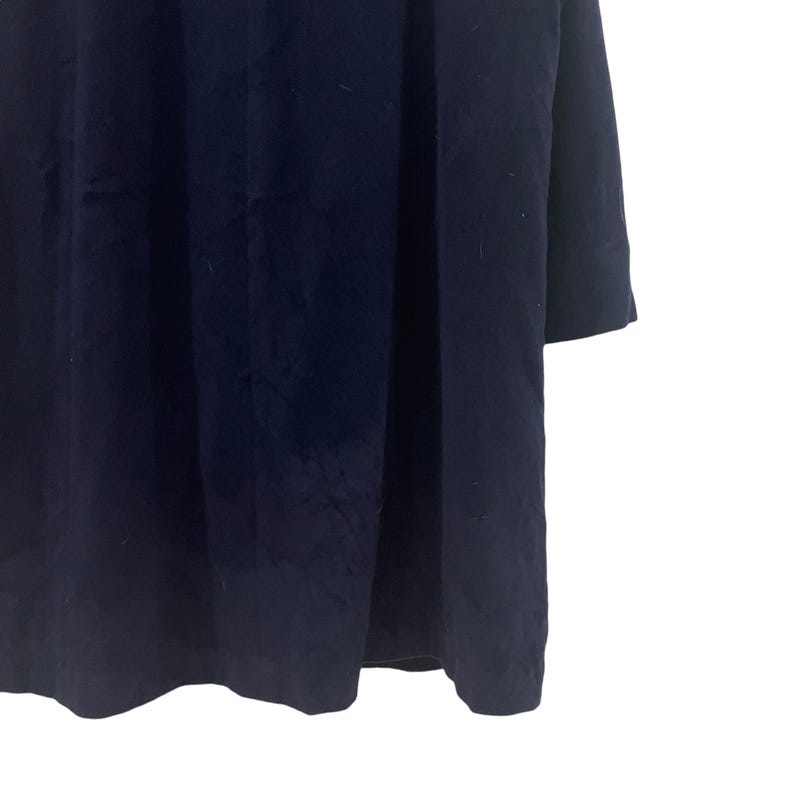 May include: A dark blue long-sleeved dress with a simple, classic design.