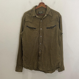 May include: A long-sleeved, button-down shirt with a checkered pattern in shades of brown and yellow. The shirt has a pointed collar, two chest pockets with black stitching, and a label that reads "WEN'S ROOM" on the left side of the chest.