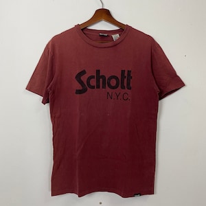May include: A maroon short-sleeved t-shirt with a black Schott N.Y.C. logo printed on the front.