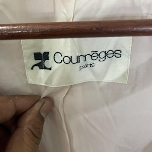 May include: A white label with black text that reads "Courr&egrave;ges Paris" with a stylized "C" logo.