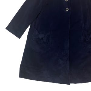 May include: A navy blue velvet coat with a single button closure and two pockets with decorative bows. The coat has a long, flowing silhouette.
