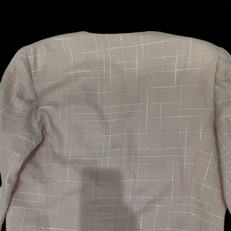 May include: A pink blazer with a white grid pattern. The blazer is made of a soft, lightweight fabric and has a classic, tailored fit.