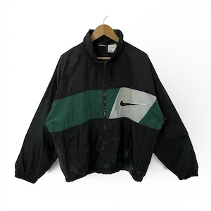 May include: Black and green Nike windbreaker jacket with a full zipper closure. The jacket features a color block design with a green stripe across the chest and a gray and black Nike swoosh logo.