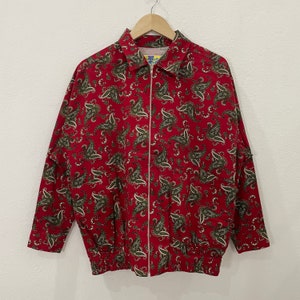 Könnte beinhalten: Eine rote Jacke mit Paisley-Muster und Reißverschluss. Die Jacke hat einen Kragen und lange Ärmel.