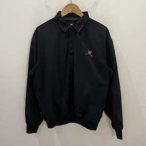 Könnte beinhalten: Schwarzes Langarm-Pullover-Shirt mit Kragen und einem kleinen gestickten Logo mit gekreuzten Golfschlägern und einem Herz. Das Shirt hat eine Knopfleiste und elastische Bündchen.