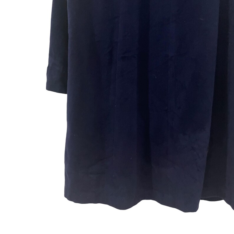 May include: A navy blue long-sleeved dress with a simple, elegant design.
