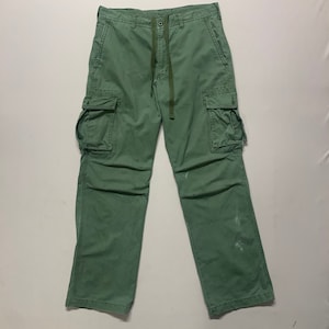 Peut inclure: Un pantalon cargo vert avec plusieurs poches et une taille à cordon.