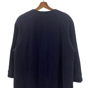 May include: A dark blue long-sleeved shirt with a raglan sleeve design. The shirt is made of a soft, comfortable fabric.