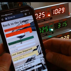 May include: A smartphone screen displaying a "Back to the Future" themed app with a digital clock interface. The app allows users to set a destination time, present time, and last time departed. The screen also shows a display brightness setting. The phone is held in front of a vintage-style digital clock with a red and green display.