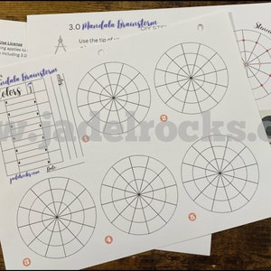 May include: A set of five printable mandala templates for creating art. The templates are printed on white paper and feature a compass, a colour chart, and a gridded circle design. The text "3.0 Mandala Brainstorm" is printed at the top of the page.