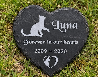 May include: A heart-shaped black slate memorial stone featuring an engraved silhouette of a cat, the name Luna, the text Forever in our hearts, the years 2009-2020, and a small heart icon containing a cat profile silhouette.