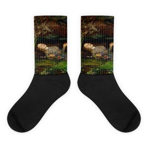May include: Black socks displaying a painting of a person in water, surrounded by foliage. The artwork uses muted colours to create a tranquil scene. The socks are crew length, a classic style.