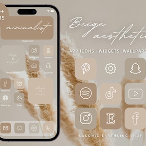 Puede incluir: Una pantalla de inicio de teléfono minimalista beige y blanca con iconos de aplicaciones y widgets. Los iconos están delineados en blanco y presentan aplicaciones populares como Instagram, Amazon, Snapchat, Facebook, Chrome, Spotify, TikTok, YouTube, Pinterest, y más. El texto "Beige aesthetic" está escrito en cursiva en la parte superior de la imagen. El texto "APP ICONS - WIDGETS - WALLPAPERS" está escrito debajo del texto en cursiva. El texto "LACONIC EARTHLING SHOP" está escrito en la parte inferior de la imagen.