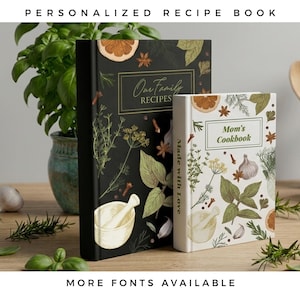 May include: Two hardback recipe books, one black and one white, featuring botanical illustrations of herbs, spices, and a mortar and pestle. The black book is titled "Our Family RECIPES" and the white book is titled "Mom's Cookbook" with "Made with Love" on the spine.