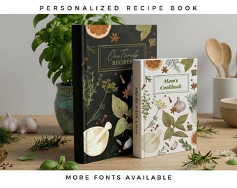 May include: Two hardcover recipe books, one black and one white, featuring botanical illustrations of herbs, spices, and a mortar and pestle. The black book is titled "Our Family RECIPES" and the white book is titled "Mom's Cookbook" with "Made with Love" on the spine.