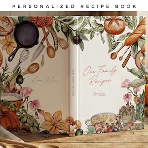 Op de afbeelding: Een gepersonaliseerd receptenboek met een crèmekleurige kaft voorzien van aquarelillustraties van keukengerei, groenten en brood. De voorkant toont de tekst "Our Family Recipes" en "Est. 2025", terwijl de achterkant "Love, Mom" toont.