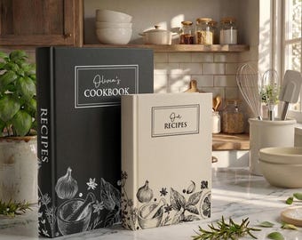 May include: Two hardcover recipe books, one black and one cream, featuring white and black line art illustrations of herbs and a mortar and pestle. The black book is titled Olivia's COOKBOOK and the cream book is titled Our RECIPES.