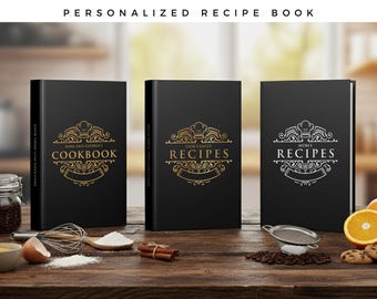 Könnte beinhalten: Drei schwarze personalisierte Rezeptbücher mit gold- und silbergeprägten Designs. Die Bücher stehen auf einer Holzoberfläche mit Kochzutaten wie Eiern, Mehl und Orangen. Die Texte auf den Büchern lauten "Cookbook", "Recipes" und "Recipes".