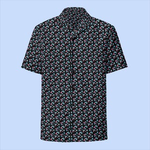 Pode incluir: Camisa preta de manga curta com estampa floral. A camisa apresenta um padrão repetido de pequenas flores rosa e azul claro sobre um fundo preto. Possui gola clássica e fechamento por botões.