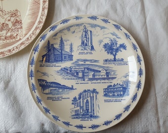 Könnte beinhalten: Zwei dekorative Teller. Ein Teller zeigt ein Kartendesign in Braun. Der andere Teller ist weiß mit blauen Illustrationen von Sehenswürdigkeiten und Text, darunter "Fort Vancouver" und "Interstate Bridge".