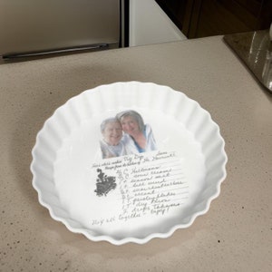 May include: A white ceramic fluted tart dish featuring a printed photograph of two people and a handwritten recipe for Veg Dip. The text includes ingredients like Hellmann's, sour cream, and dill weed, along with a small illustration of a vintage stove.