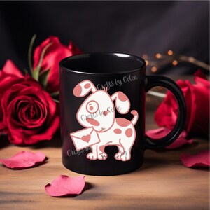 Puede incluir: Taza de cerámica negra con un diseño de perro de dibujos animados. El perro es blanco con manchas rosas y sostiene una carta con un corazón. La taza tiene el texto "Crafts by Colon". Rosas rojas y pétalos en el fondo.