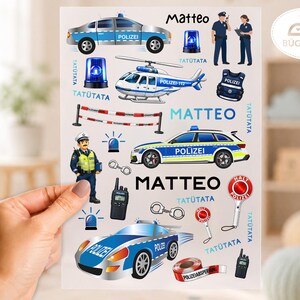 Könnte beinhalten: Ein Bogen mit Bügelbildern im Polizeidesign, bestehend aus Streifenwagen, einem Hubschrauber, Polizisten, Handschellen, Funkgeräten, Blaulichtern und rot-weißem Absperrband, ergänzt durch den Namen Matteo in schwarzer Schrift.