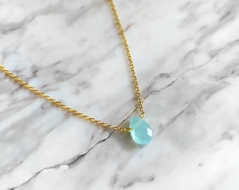 May include: A delicate gold chain necklace with a single light blue gemstone pendant.