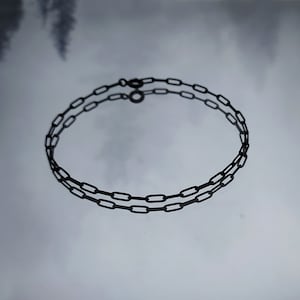 May include: A black chain necklace with a simple, linked design. The chain is made of metal and has a matte finish.
