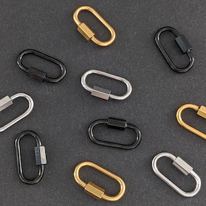 Könnte beinhalten: Sortiment aus zehn ovalen Schlüsselanhängern aus Metall mit einem Drehverschluss. Die Schlüsselanhänger sind in Schwarz, Silber und Gold.