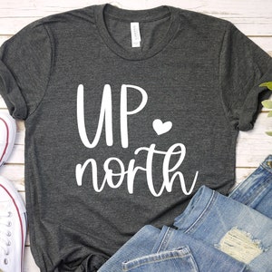 May include: A dark heather gray t-shirt with the text "UP north" in white with a small white heart.