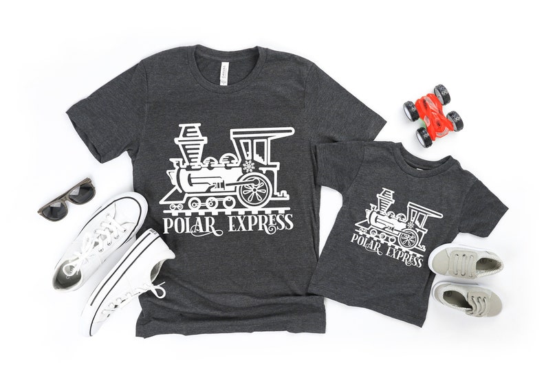 May include: Two gray t-shirts with a white graphic of a train and the text "Polar Express".