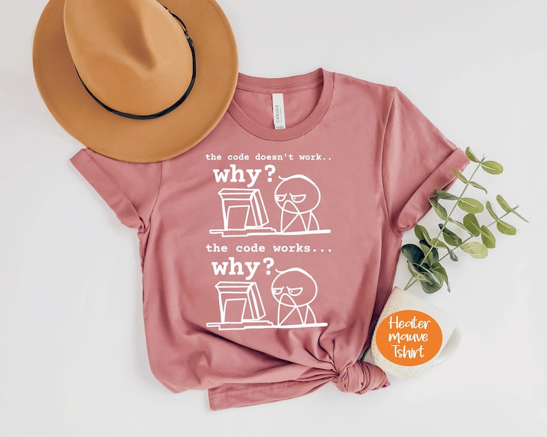 May include: A mauve t-shirt with a white graphic of a stick figure at a computer with the text "the code doesn't work... why?" and "the code works... why?"