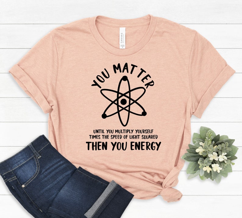 May include: A peach-coloured t-shirt with a black atom graphic and the text "You Matter Until You Multiply Yourself Times The Speed Of Light Squared Then You Energy".
