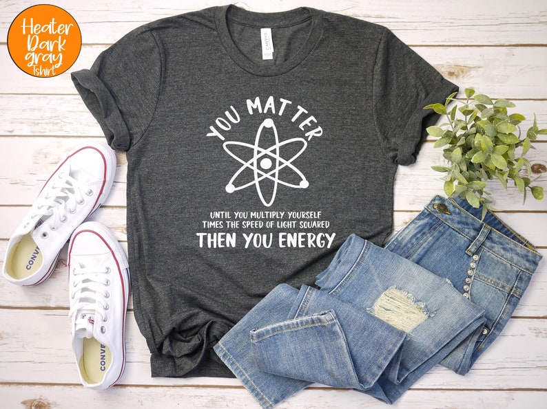 May include: A dark grey t-shirt with a white graphic of an atom and the text "You Matter Until You Multiply Yourself Times The Speed Of Light Squared Then You Energy".