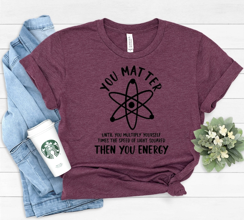 May include: A maroon t-shirt with a black atom graphic and the text "You Matter Until You Multiply Yourself Times The Speed Of Light Squared Then You Energy".