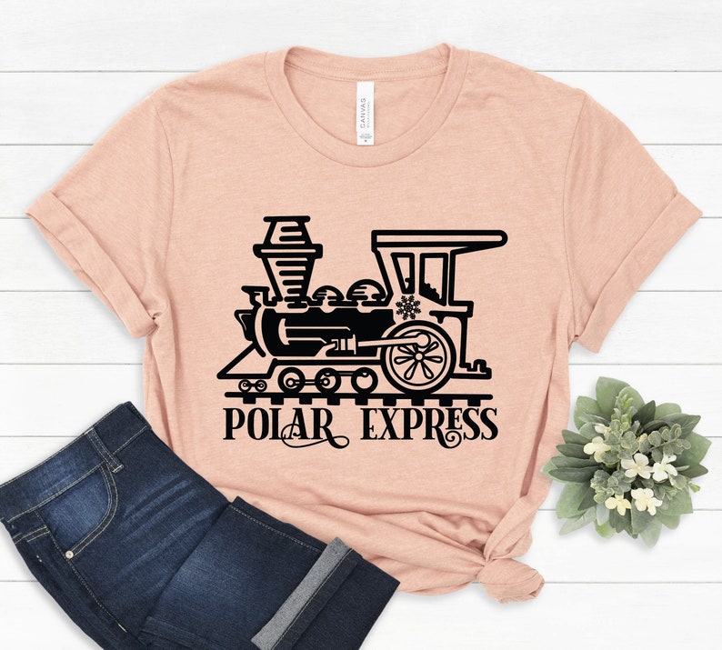 May include: A peach-colored t-shirt with a black silhouette of a train with the text "Polar Express" underneath.