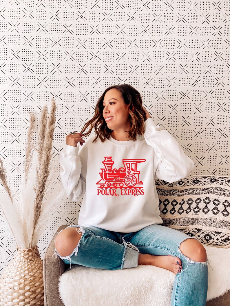 May include: White sweatshirt with a red graphic of a train and the text "POLAR EXPRESS".